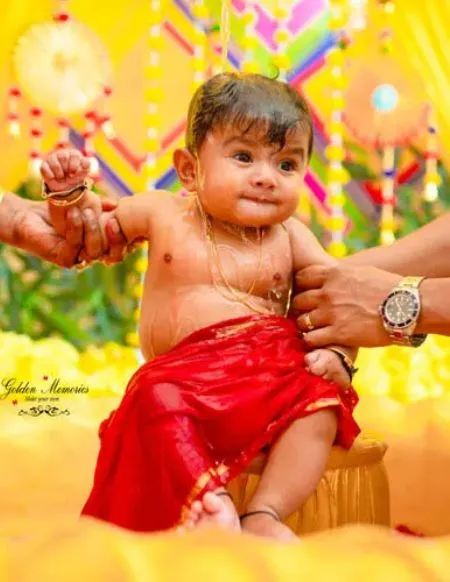 Baby dressed in traditional attire during rice ceremony captured by a professional photographer in Kolkata
